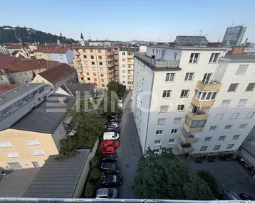 Panoramablick über die Stadt mit Wohngebäuden, einer Straße und parkenden Autos.