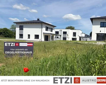 Neubau eines Ziegelfertighauses auf einem Grundstück mit weiteren Häusern im Hintergrund.