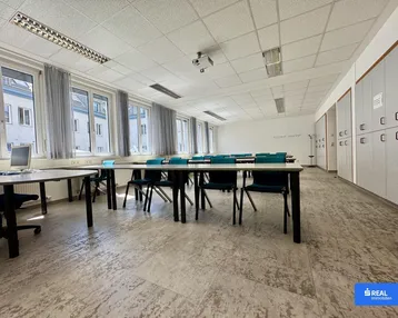 Heller Klassenraum mit großen Fenstern, viel Tageslicht, integrierten Schränken und strapazierfähigem Bodenbelag.