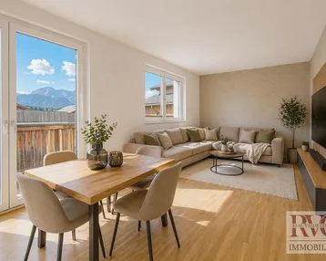 Heller Wohn- und Essbereich mit Holzboden, Zugang zum Balkon und Bergblick.
