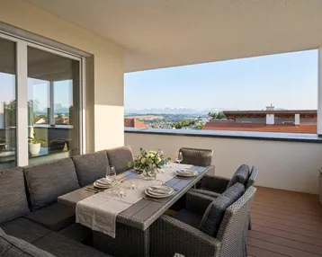 Geräumige Terrasse mit modernen Outdoor-Möbeln und weitem Blick auf die Berge und die Landschaft.