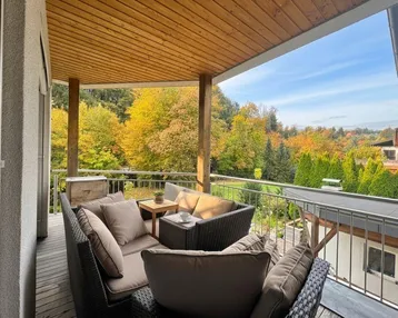 Gemütlicher Balkon mit Sitzgelegenheiten und weitem Blick ins Grüne.