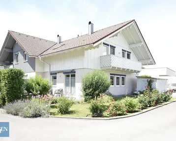 Freistehendes Einfamilienhaus mit gepflegtem Vorgarten und traditioneller Architektur in sonniger Lage.