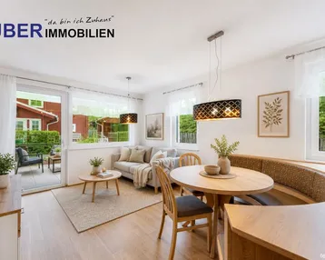 Helles Wohn- und Esszimmer mit Holzboden, gemütlicher Sitzecke und Zugang zur Terrasse.