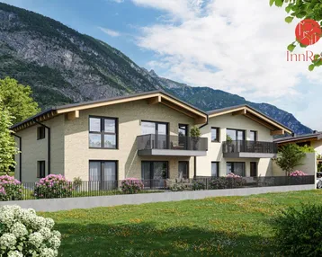 Moderne Doppelhaushälfte mit Balkonen und Bergblick, umgeben von grüner Landschaft und Blumenbeeten.