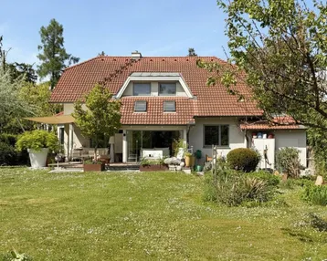 Gepflegtes Einfamilienhaus mit großem Garten, Rasenfläche und sonniger Terrasse.