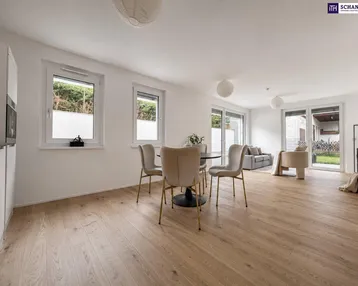 Heller, offener Wohn- und Essbereich mit Holzboden und Zugang zum Garten.