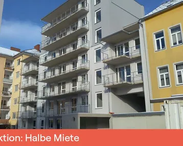 Modernes Mehrfamilienhaus mit zahlreichen Balkonen und großen Fenstern in städtischer Umgebung.