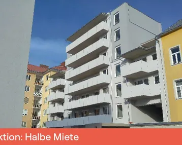 Modernes Mehrfamilienhaus mit mehreren Balkonen und heller Fassade unter blauem Himmel.