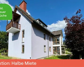 Freistehendes Haus mit Balkon und Garten in ländlicher Umgebung unter blauem Himmel.