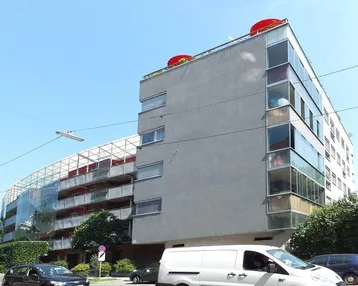 Moderne Wohnanlage mit markanter Architektur, vielen Balkonen und großen Glasflächen.