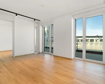 Heller Wohnraum mit Parkettboden und Zugang zu einem Balkon, bereit zur individuellen Gestaltung.