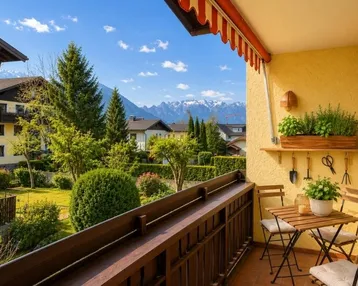 Gemütlicher Balkon mit Sitzgelegenheiten, Pflanzen und herrlichem Bergblick über die grüne Umgebung.
