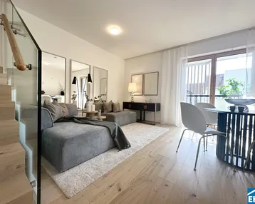 Moderner Wohn-Essbereich mit Holzboden, gemütlichem Sofa und Zugang zum Balkon.