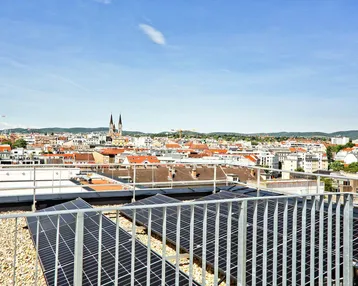 Dachansicht mit Photovoltaikanlage und weitem Blick über die Stadt und historische Kirchtürme.