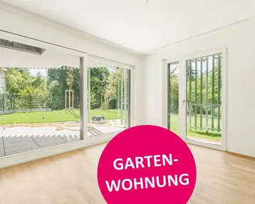 Helles Zimmer mit Holzboden und großen Schiebetüren zum Garten und zur Terrasse.