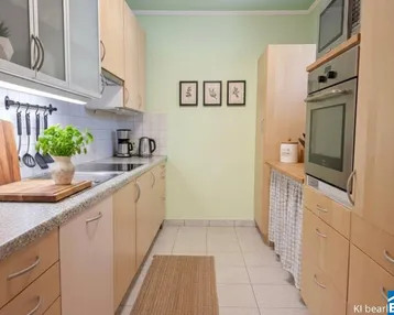 Funktionale Küche mit hellen Holzfronten, Fliesenboden und integrierten Geräten.