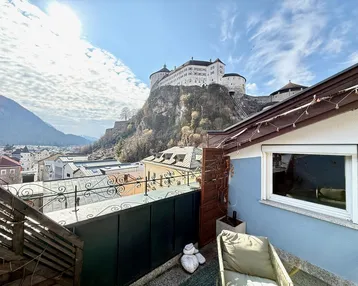 Kleiner Balkon mit Sitzgelegenheit und beeindruckendem Blick auf die Burg und die Berge.