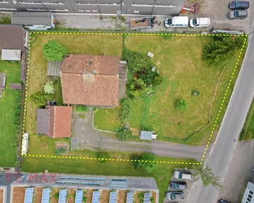 Luftaufnahme des Grundstücks mit gelber Umrandung, zeigt das Haus, Garten und die umliegende Gewerbezone.