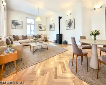 Helles Wohn- und Esszimmer mit Fischgrätparkett, modernem Kaminofen und stilvoller Einrichtung.