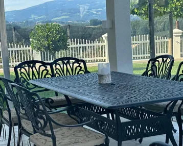 Gemütlicher Essbereich im Freien mit schmiedeeisernen Möbeln und Bergblick.