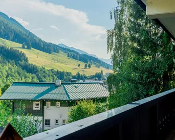 Geräumiger Balkon mit Holzboden und atemberaubendem Blick auf die umliegenden Berge und grüne Täler.