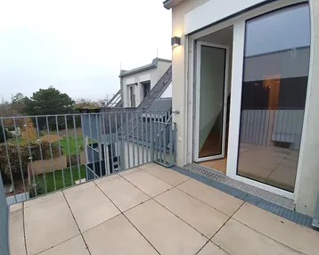 Geräumiger Balkon mit Fliesenboden und Blick auf die Umgebung, ideal für entspannte Stunden im Freien.