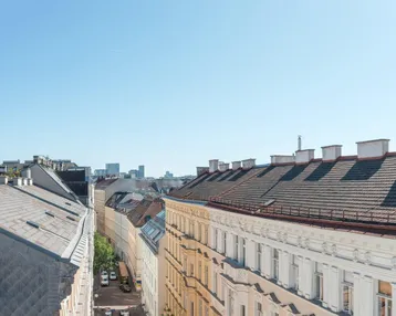 Blick über die Dächer traditioneller Gebäude in einer städtischen Umgebung mit Fernsicht.