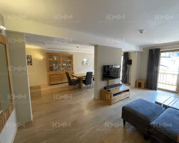 Geräumiger Wohn-Essbereich mit Holzboden, modernem Mobiliar und Zugang zum Balkon.
