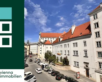 Blick auf eine belebte Straße mit historischen Gebäuden und einer Kirche im Hintergrund.