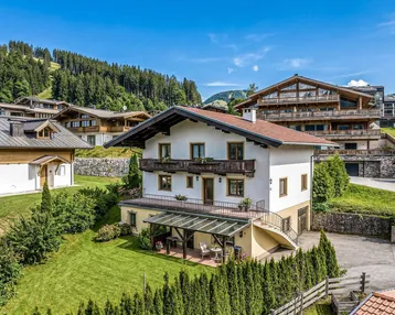 Charmantes Haus mit Garten, überdachter Terrasse und Bergblick in alpiner Umgebung.