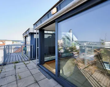 Große Dachterrasse mit Fliesenboden und weitem Blick über die Stadt, ideal für Entspannung im Freien.