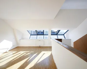 Heller Wohnbereich mit Dachfenstern, Holzboden und viel natürlichem Licht.