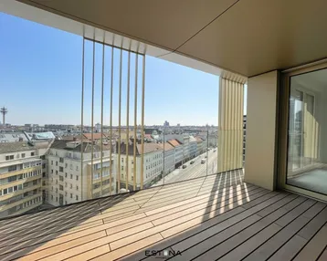 Geräumiger Balkon mit Holzboden und weitem Blick über die Stadt.