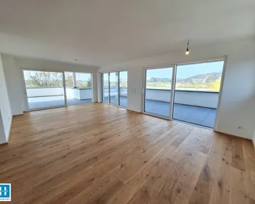Helles, geräumiges Wohnzimmer mit neuem Parkettboden und Zugang zu einer großen Terrasse.