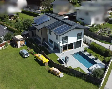 Luftaufnahme des Hauses mit Pool, Garten und Photovoltaikanlage auf dem Dach.