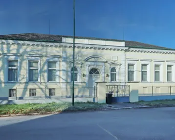Historische Fassade eines Gebäudes mit klassischer Architektur und hellgelbem Anstrich.