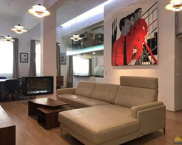 Geräumiger Wohn- und Essbereich mit modernem Kamin, hohen Decken und Zugang zu einer Galerie.