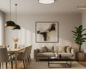 Helles, modern eingerichtetes Wohn-Esszimmer mit beigem Sofa, Holztisch und stilvoller Dekoration.