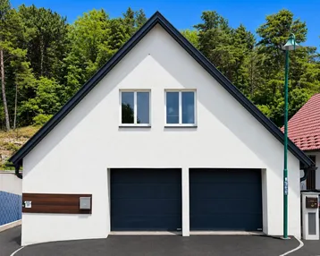 Moderne Hausfassade mit zwei Garagentoren und Satteldach, umgeben von Bäumen.
