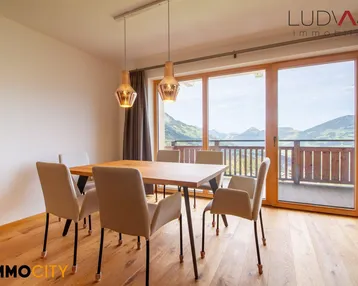 Heller Essbereich mit Holzboden und großen Fenstern, die einen weiten Bergblick bieten.