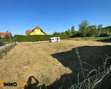 Sonniges Grundstück mit freiem Blick auf die umliegende Landschaft und Nachbarhäuser.