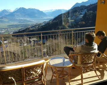 Geräumiger Balkon mit Sitzgelegenheiten und atemberaubendem Bergblick, ideal zum Entspannen.