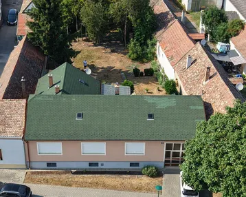 Luftaufnahme des Hauses mit grünem Dach, Vorgarten und großem Hinterhof in ländlicher Umgebung.