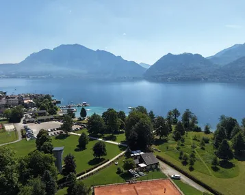 Panoramablick auf den See, die Berge und die umliegende Landschaft mit Sportanlagen.