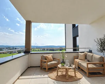 Geräumiger Balkon mit bequemen Outdoor-Möbeln und weitem Blick über die Landschaft.