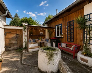 Gemütlicher Außenbereich mit überdachter Sitzecke und Holzwänden, ideal für entspannte Stunden im Freien.