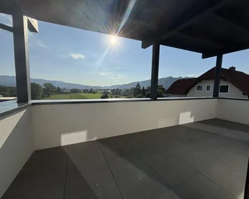 Große Sonnenterrasse mit moderner Pergola, Fliesenboden und weitem Blick auf Berge und grüne Landschaft.