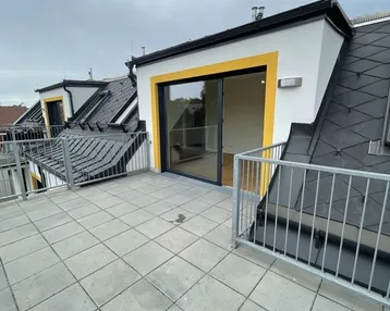 Geräumige Dachterrasse mit modernen Fliesen und Blick auf die Umgebung, zugänglich vom Innenbereich.