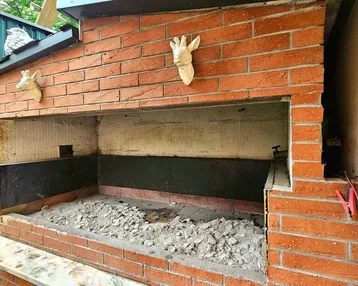 Gemauerter Außenofen oder Grillplatz mit Ziegelsteinen und dekorativen Elementen.